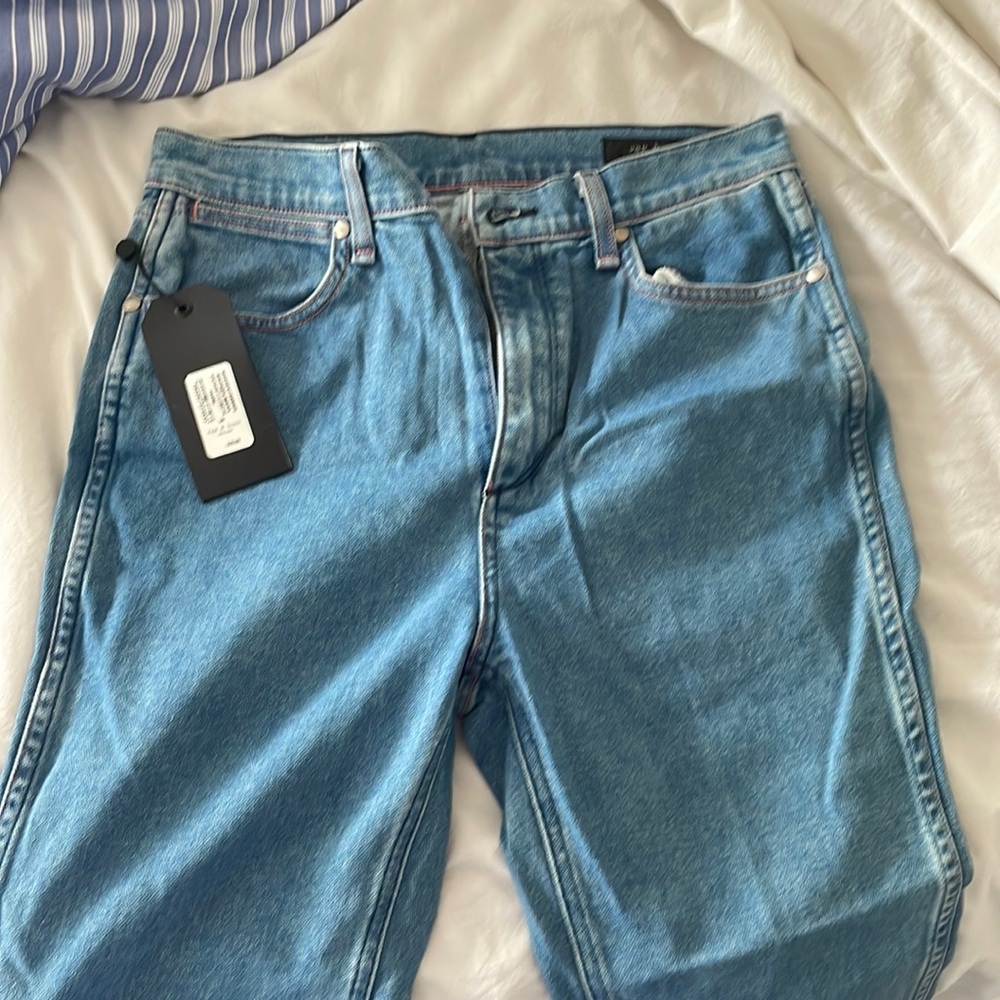 Straight leg jean **length has been hemmed but excess fabric still attached**